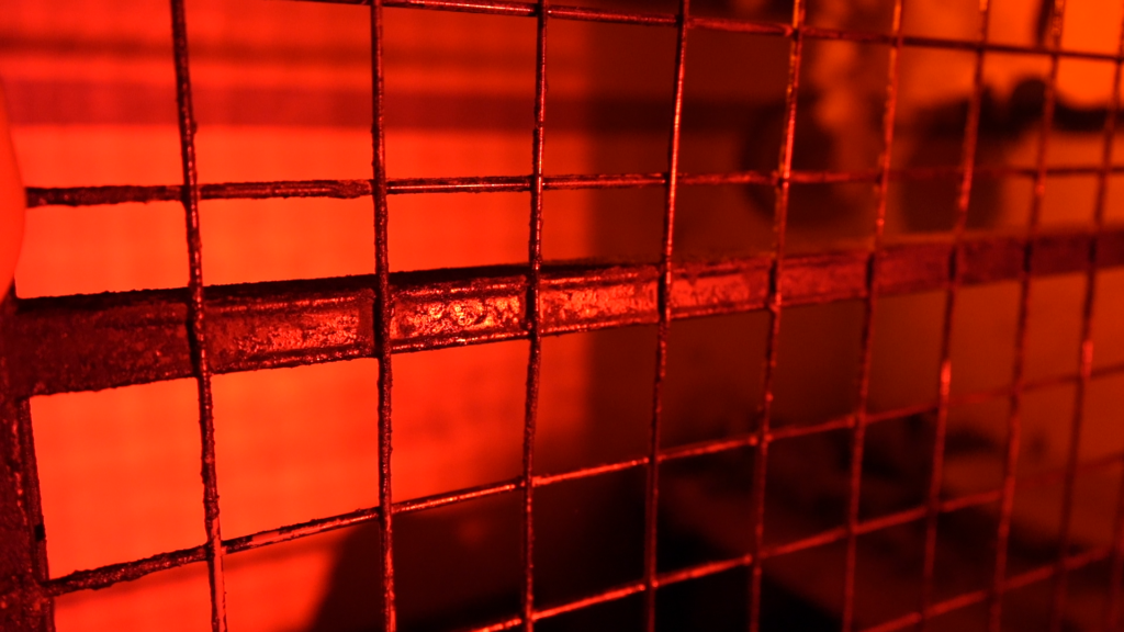 Rot beleuchtetes Metallgitter als bedrohliche Kulisse des FSK-18-Horror-Live-Theaters