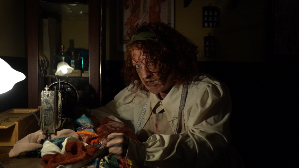 Schauspieler in historischem Kostüm bei einer unheimlichen Handarbeit, Teil des Live-Casts von „Rückkehr nach Innsmouth
